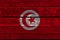 Photograph of the beautiful colored national flag of the modern African state of Tunisia on textured fabric, concept of tourism,