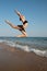 Photograph of a beautiful female dancer jumping on a beach in t