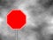 Photograph of a blank red traffic stop sign with rectangular white bordered. Text letters have been removed. Stop sign on grey sky