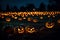 A Photograph capturing the mesmerizing glow of pumpkins scattered in an eerie graveyard,