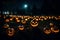 A Photograph capturing the mesmerizing glow of pumpkins scattered in an eerie graveyard, illuminating the night with a hauntingly