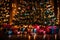 A Photograph capturing the vibrant glow of a Christmas tree adorned with twinkling lights, surrounded by beautifully wrapped gifts