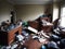 Photograph of a cluttered living space filled with trash debris broken furniture