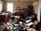 Photograph of a cluttered living space filled with trash debris broken furniture