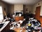 Photograph of a cluttered living space filled with trash debris broken furniture