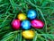 photograph of colored easter eggs on grass nest.