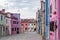 Photograph colourful houses in a square on the island of Burano, Venice.