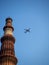 Photograph of a commercial aircraft passing by a high tower in Jaipur, India