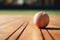 photograph of a cricket players ball rests on wooden basketball court