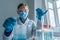 The photograph depicts a biologist conducting experiments on cells in a biotechnology laboratory to study biological