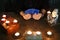 Photograph of hands holding a deck of tarot cards and candles.