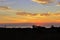 Photograph of a landscape with a view of the sun rising from the sea and clouds