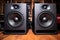 photograph of large professional studio monitors speakers on a desk