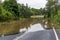 Photograph of a river flooding across a road in regional Australia