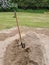 A photograph of a shovel in a pile of construction sand