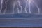 Photograph of Wind Turbines on a hill during a lightning storm