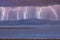 Photograph of Wind Turbines on a hill during a lightning storm