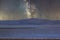 Photograph of Wind Turbines on a hill at night under stars