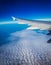 Photograph of the wing of an airplane from inside with a beautiful blue sky