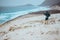 Photographer admitting unique others worldly landscape of sand dunes volcanic cliffs on the Atlantic coast. Baia Das
