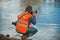 Photographer on the bank of a deep puddle