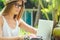 Photographer blonde female working outdoor retoucher and drinking coconut