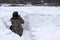 Photographer in camouflage jacket taking pictures from ambush in winter