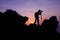 Photographer climbing on the top of the mountain to take a picture at sunset