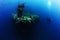 Photographer diver scuba take a photo or video near reef ocean.