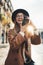 Photographer in glasses with retro photo camera. Tourist portrait smiling girl in hat travels in Barcelona holiday. Sunlight flare