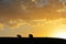 Photographer hanging tripod on hill in sunrise