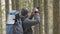 Photographer with hiking backpack taking pictures of nature with digital photo camera.