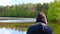 A photographer on a lake takes photos with the lake in the background