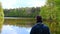 A photographer on a lake takes photos with the lake in the background