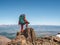 Photographer with a large backpack on the edge of a cliff. Dangerous mountains and abyss