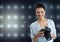 photographer smiling looking to the photos on camera .stadium lights background