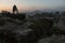 Photographer stands on the edge of the cliff, waiting for sunrise in Saxon Switzerland in autumn