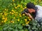 The photographer takes the camera flowers and insects. The guy with the camera in the flowers