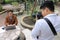 Photographer takes a photo of portrait of handsome young business man while using laptop.