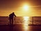 Photographer takes photos with mirror camera and tripod at end of pier board.