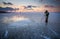 Photographer takes a picture of sunset on a frozen river