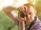 Photographer takes pictures against the background of greenery. Front view