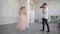 Photographer takes pictures of two beautiful girls in a white interior studio.