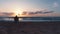 Photographer taking photos of sea and dramatic sunrise on the beach