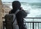 Photographer taking picture of a stormy sea in Polignano a Mare, Italy