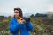 Photographer tourist girl in blue raincoat hold in female hands photo camera take photography foggy mountain, traveler shooting