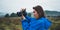 Photographer tourist girl in blue raincoat hold in female hands photo camera take photography froggy mountain, traveler shooting