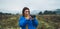 Photographer tourist girl in blue raincoat hold in female hands photo camera take photography froggy mountain, traveler shooting