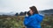 Photographer tourist girl in blue raincoat hold in female hands photo camera take photography froggy mountain, traveler shooting