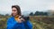 Photographer tourist girl in blue raincoat hold in female hands photo camera take photography froggy mountain, traveler shooting